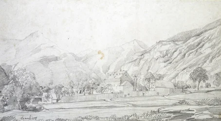 Ansicht von Gebäuden in einem ummauerten Gehege mit Bergen im Hintergrund